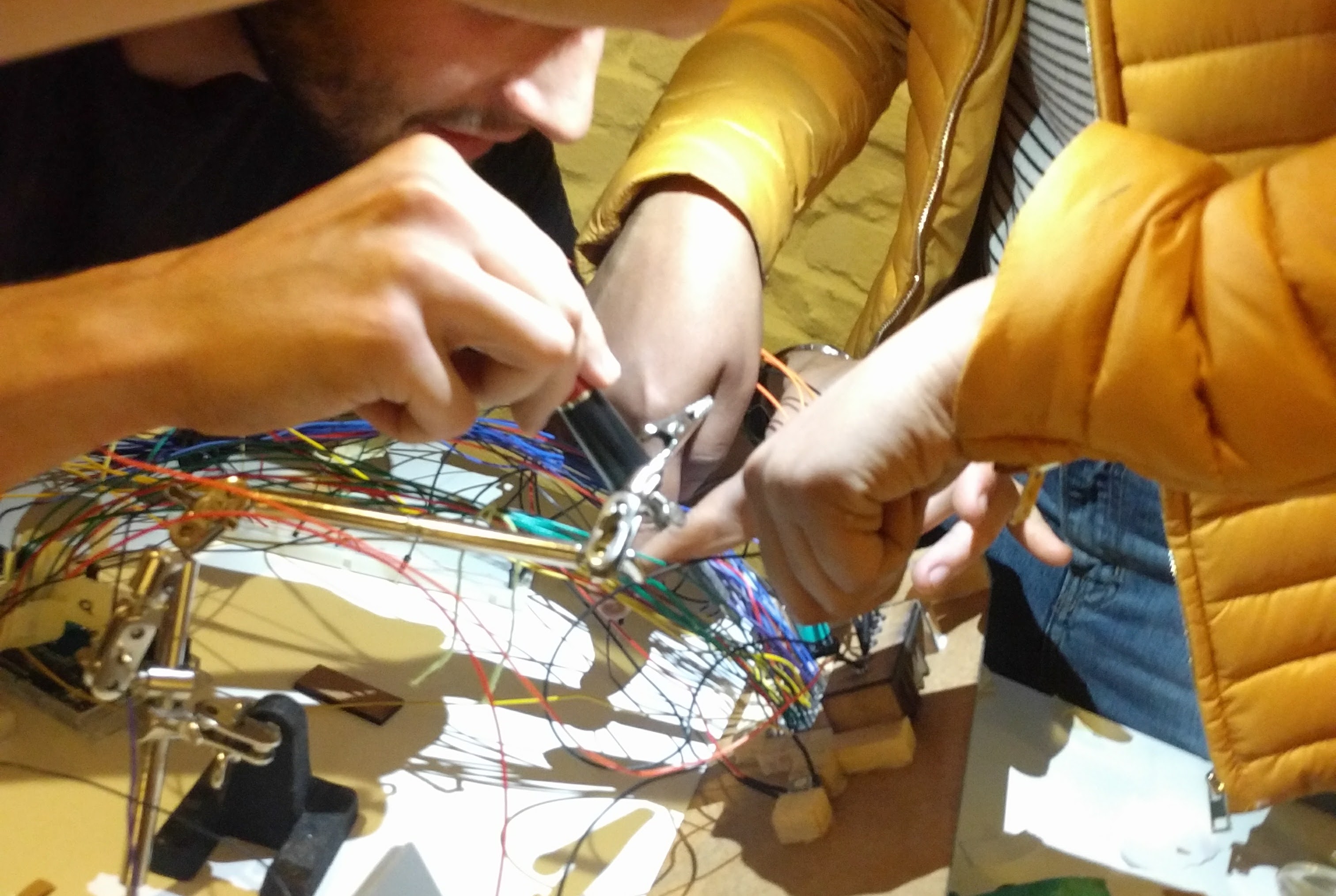 many hands attempting to fix a mess of wires